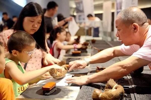 图7 我国近年来通过多种方式开展非物质文化遗产的弘扬、传播工作，图为小朋友在非物质文化遗产主题展览中体验中国活字印刷术.jpg