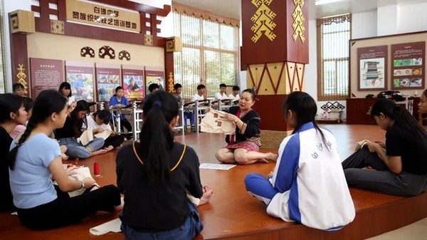 图4 海南省白沙县开展的黎族传统纺染织秀技艺进校园活动，省级代表性传承人符秀英向学生讲解绣法.jpg